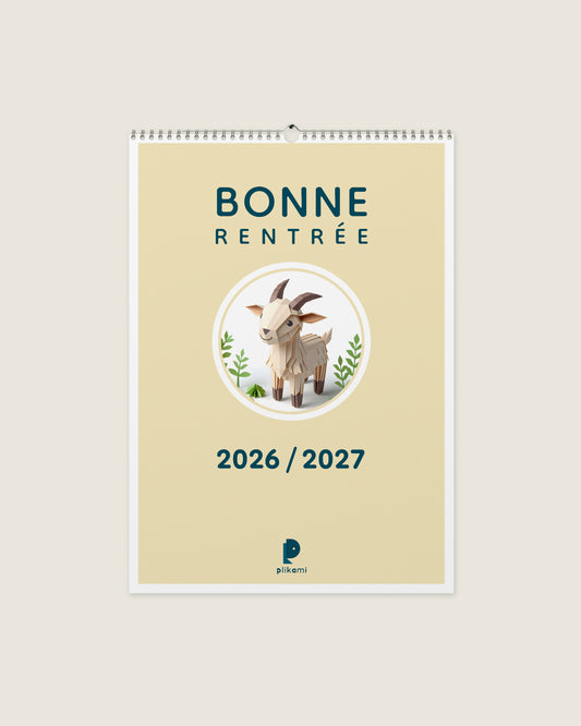 Calendrier mural à reliure spirale, couverture crème portant le titre Bonne Rentrée 2026 / 2027 et une chèvre en papier plié dans un médaillon rond.